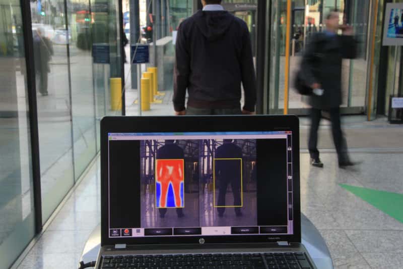 Agent de gardiennage opérant un scan X-Ray de passagers dans un aéroport.