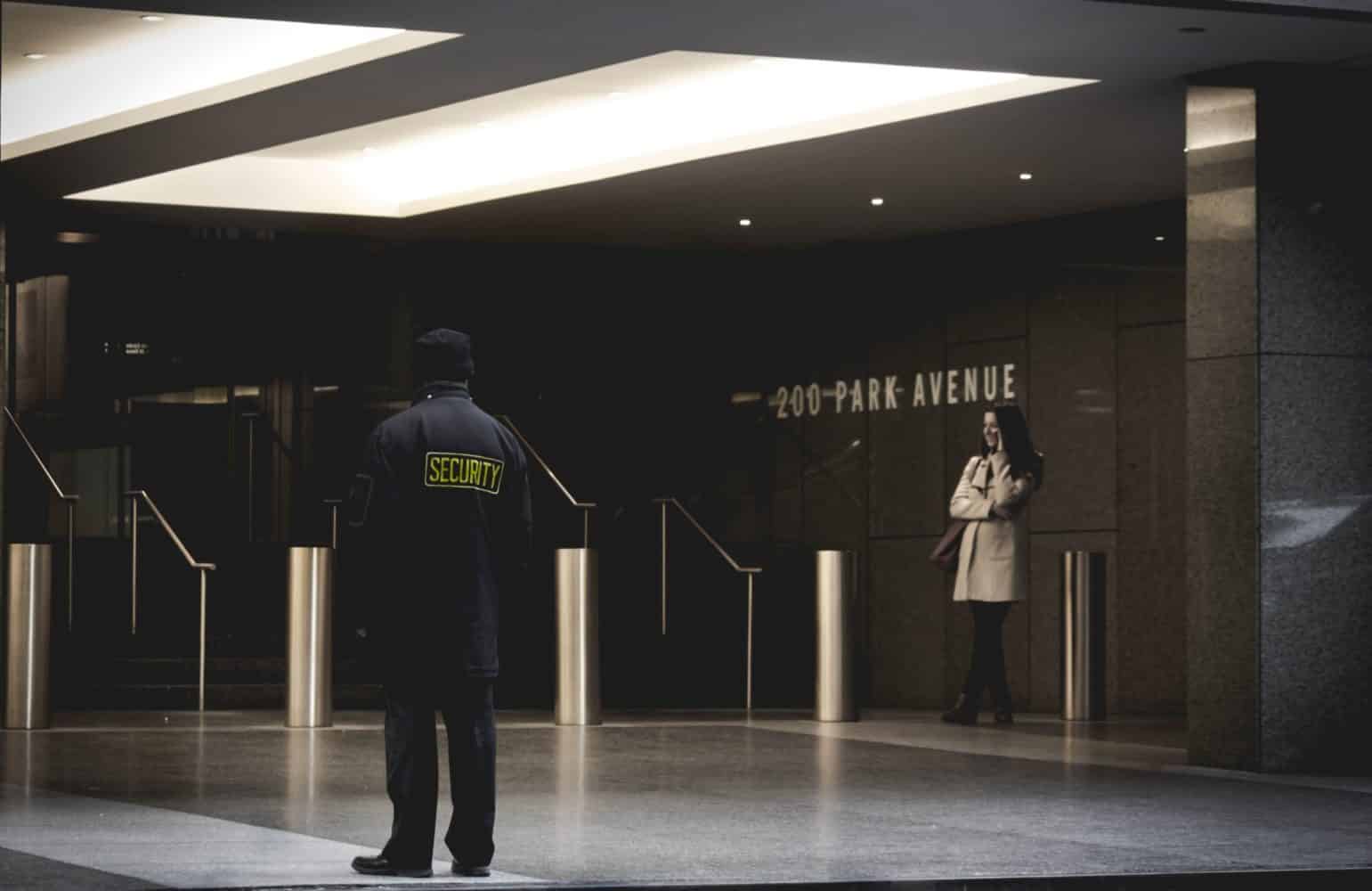 Un agent de gardiennage surveille l'entree d'un complexe de bureaux.