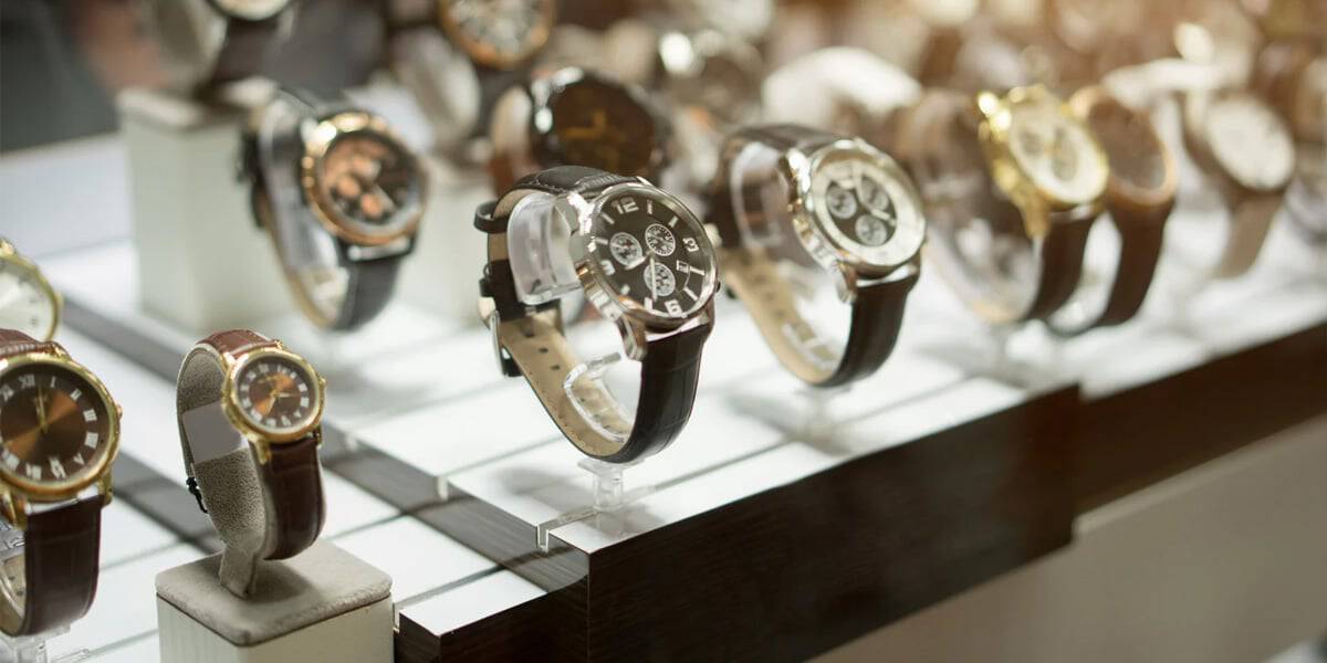 Montres de luxe dans une vitrine d'un magasin surveillé par un agent de gardiennage.