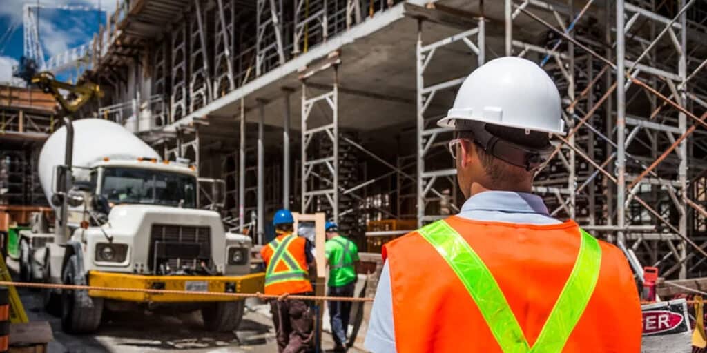 photo d'un agent de sécurité sur un chantier surveillant un camion.