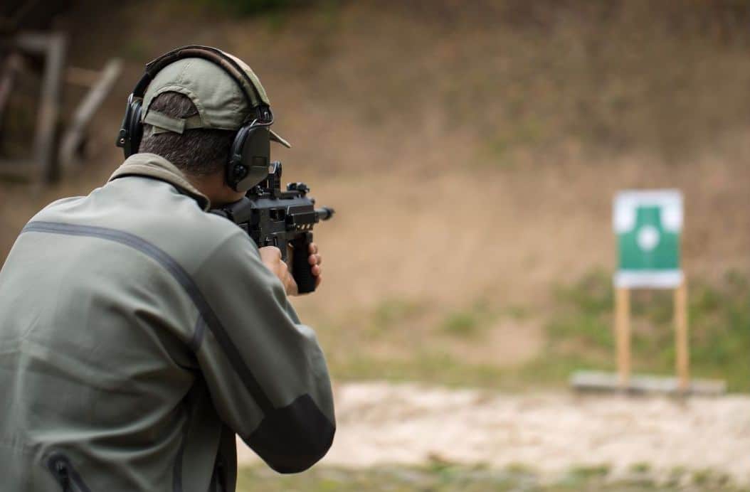 détention d'arme. Un tireur sportif vise une cible avec un fusil automatique.
