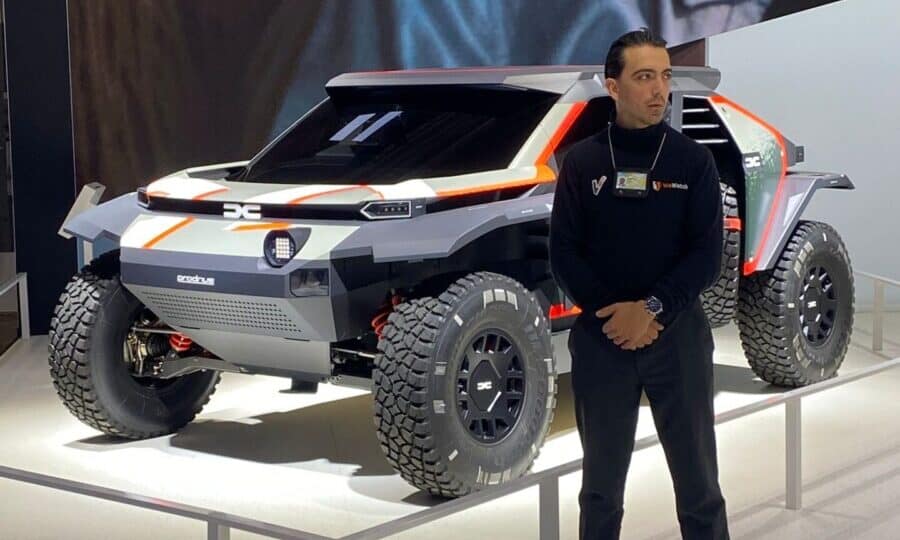 Agent WeWatch Security en uniforme surveille un véhicule de type prototype lors d'un salon automobile.