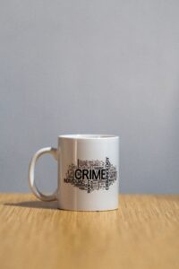 Photographie d'une tasse ornée d'un nuage de mots liés à la criminologie, notamment "Crime", pour illustrer l'analyse de la criminalité en Wallonie.