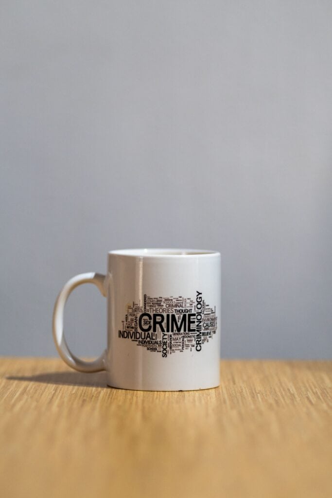 Photographie d'une tasse ornée d'un nuage de mots liés à la criminologie, notamment "Crime", pour illustrer l'analyse de la criminalité en Wallonie.